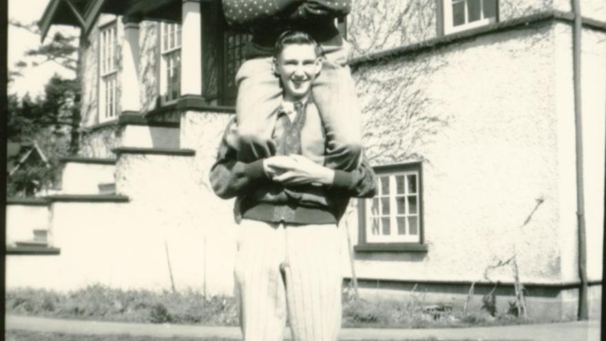 1945 image of adult with smiling child on shoulders